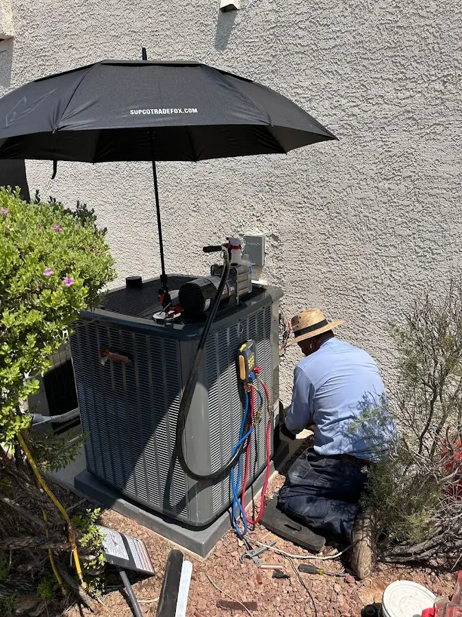 HVAC technician performing outdoor AC maintenance in Newton